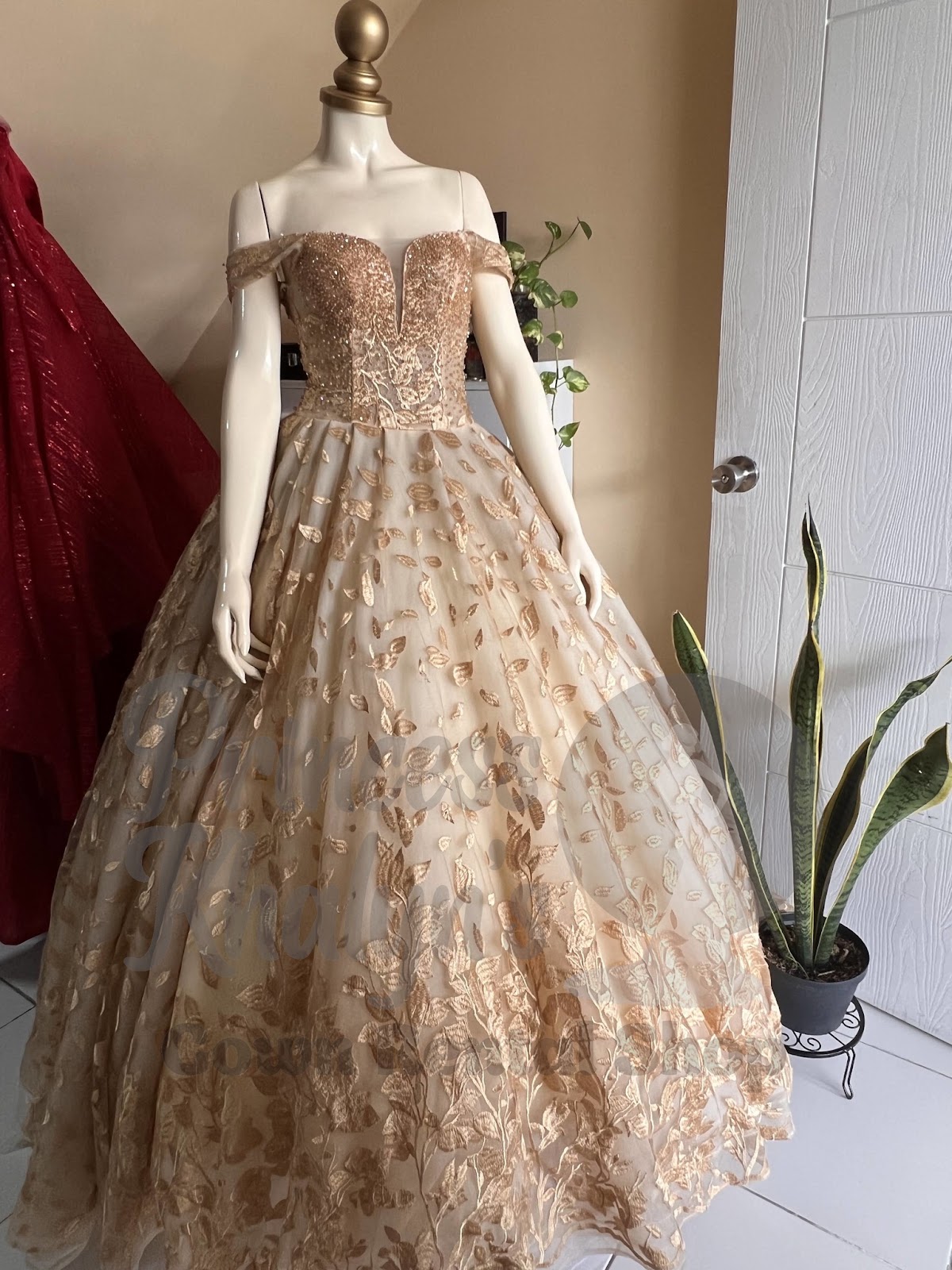 Gold off-shoulder ball gown with intricate floral embroidery and shimmering bodice