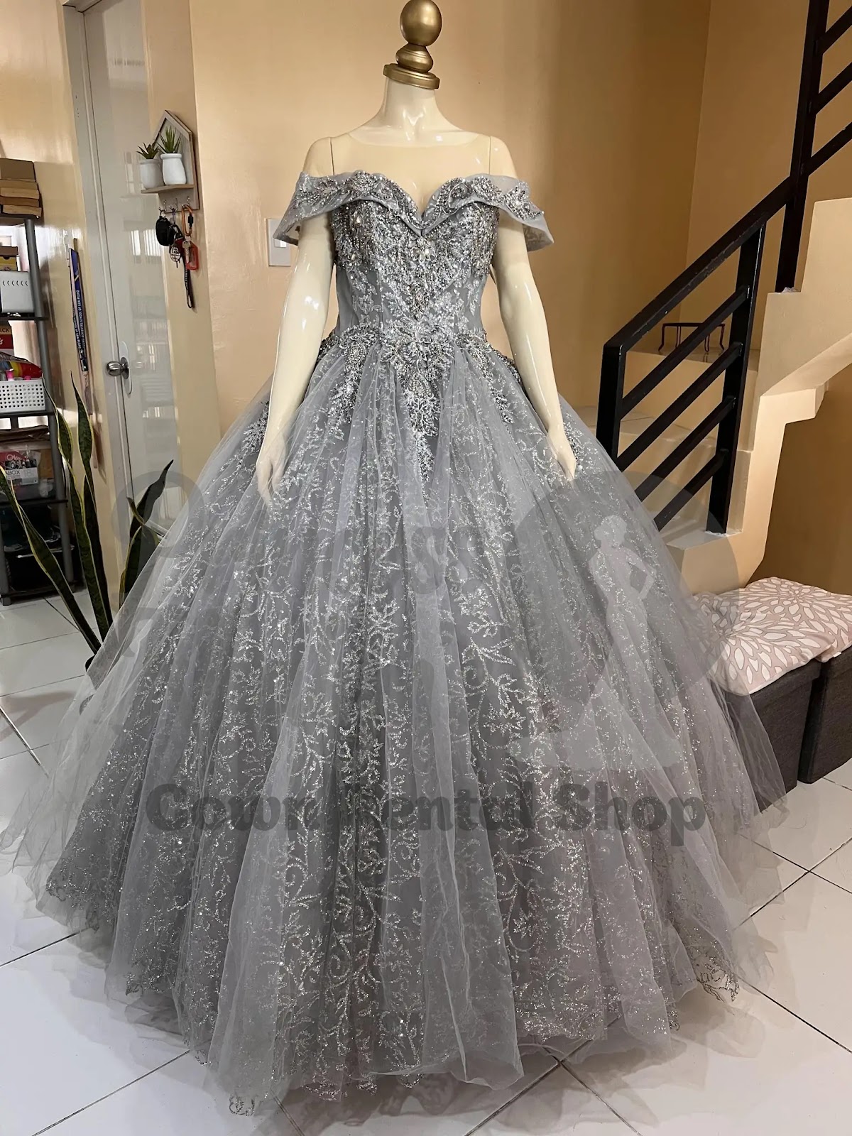 Silver off-shoulder ball gown with ornate glittering embroidery and a voluminous tulle skirt