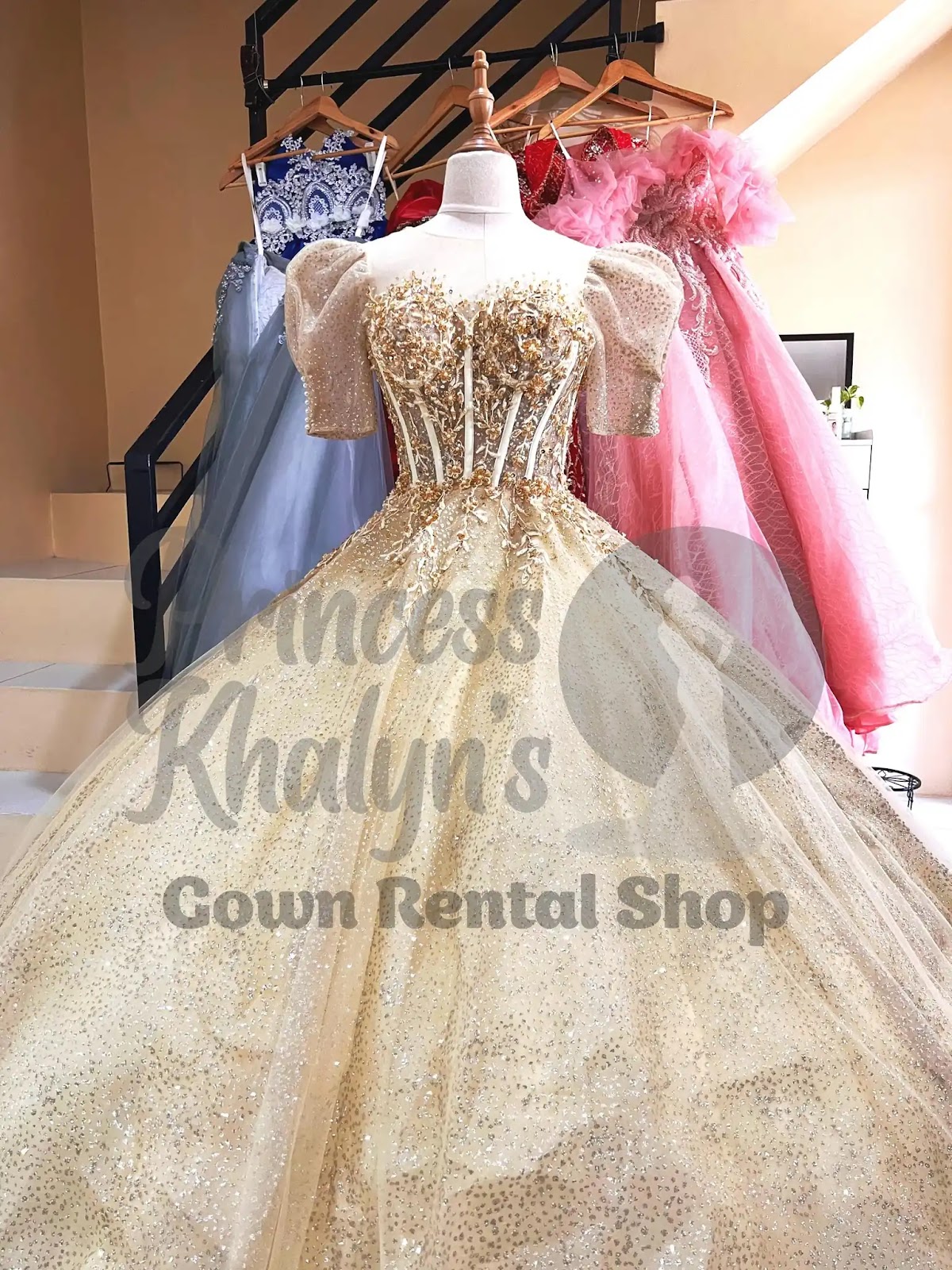 Gold ball gown with glittery puff sleeves, corset-style bodice, and cascading sequin embellishments over a full tulle skirt
