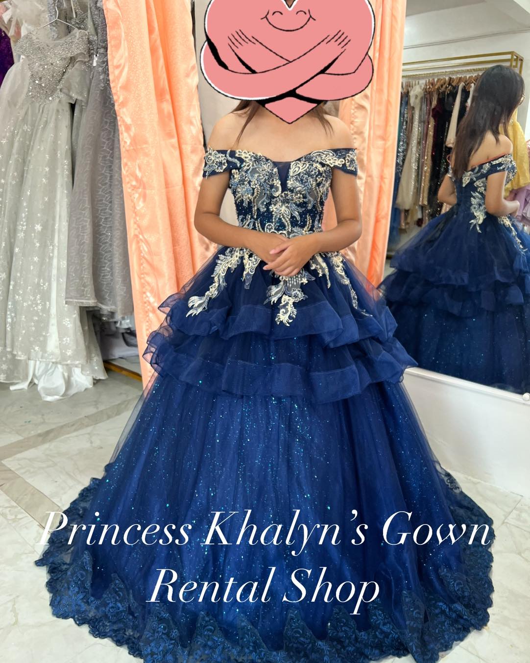 Navy blue off-shoulder ball gown with intricate gold embroidery on the bodice, layered ruffles, and a sparkling tulle skirt, creating an enchanting and elegant look.