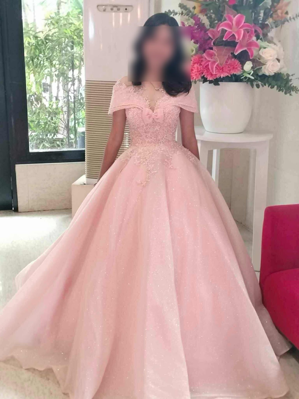 A stunning pink ball gown featuring an off-shoulder design with intricate embellishments and a flowing skirt, perfect for formal occasions.