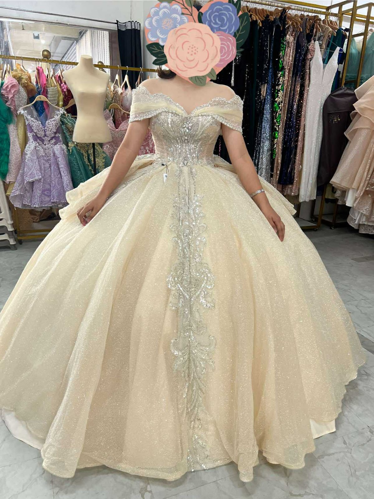 A stunning gold ball gown featuring off-the-shoulder sleeves and intricate beadwork, perfect for formal occasions.