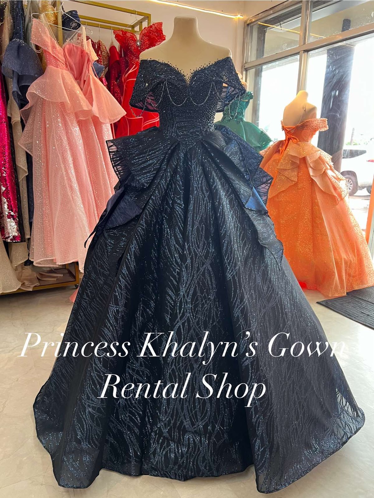 A stunning navy gown featuring an off-the-shoulder design with intricate beading and layered ruffles, perfect for formal occasions.