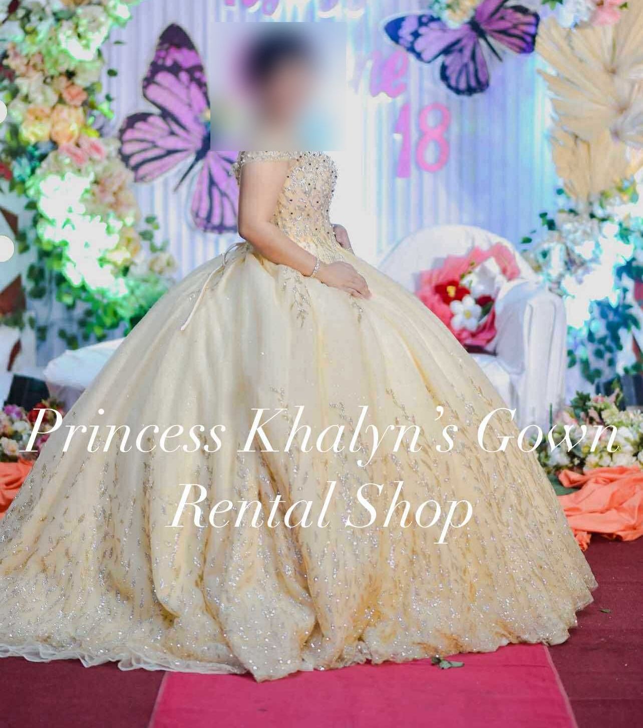 A stunning gold ball gown adorned with intricate beadwork and a voluminous skirt, perfect for formal occasions.