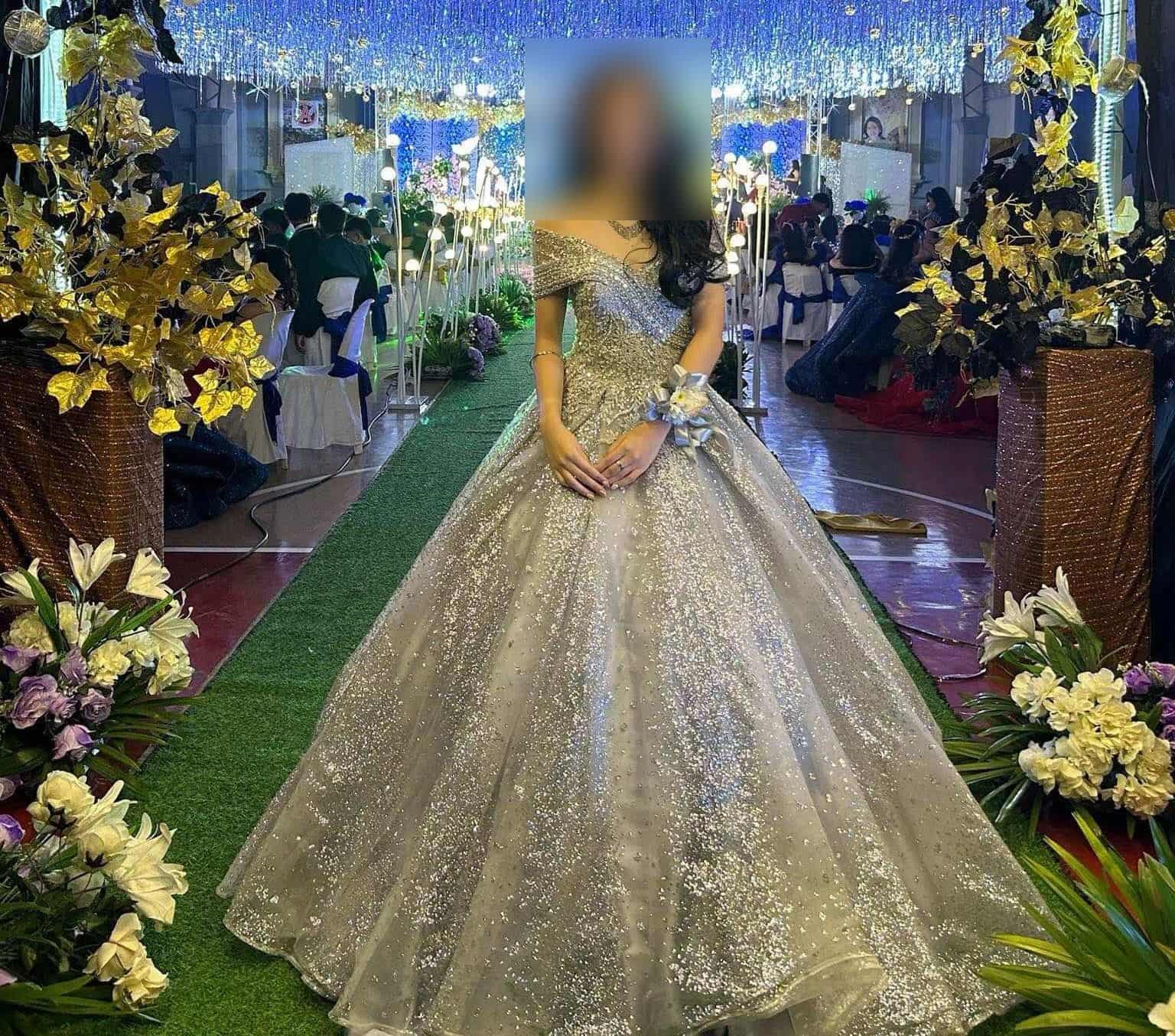 This enchanting silver gown features a shimmering bodice and a voluminous skirt, perfect for making a statement at any elegant occasion.