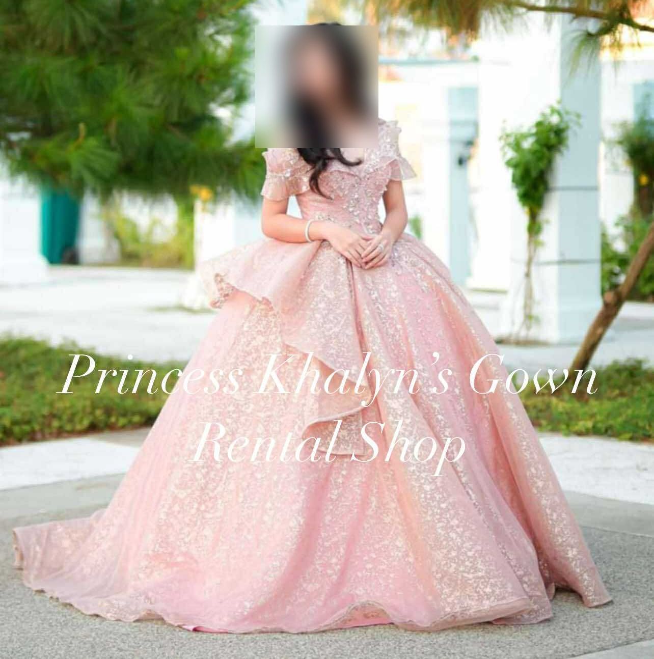 A stunning pink ball gown featuring a layered skirt and delicate embellishments, perfect for making a grand entrance at any formal occasion.