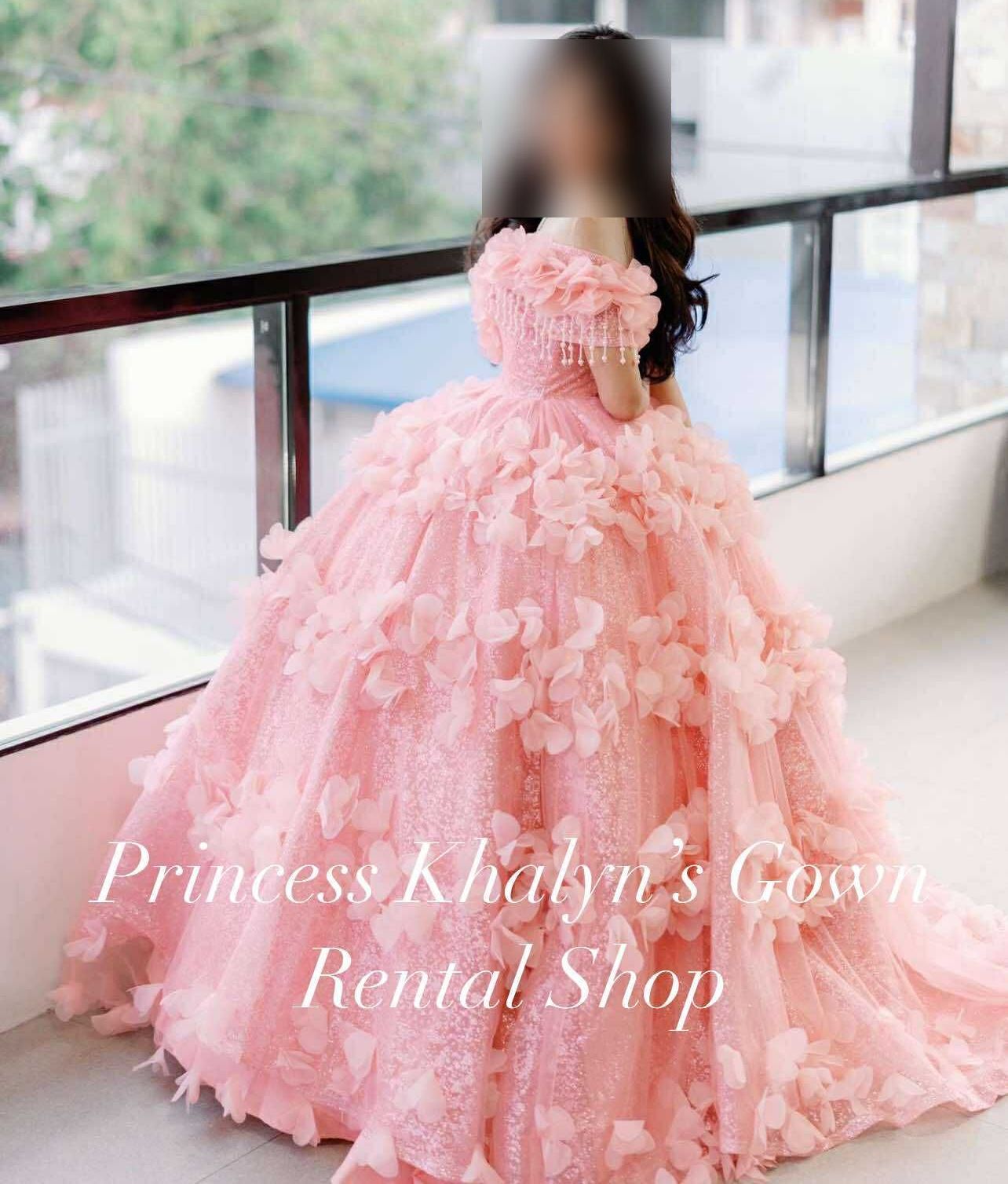 A stunning pink gown adorned with delicate floral appliqués and elegant beading, perfect for special occasions.