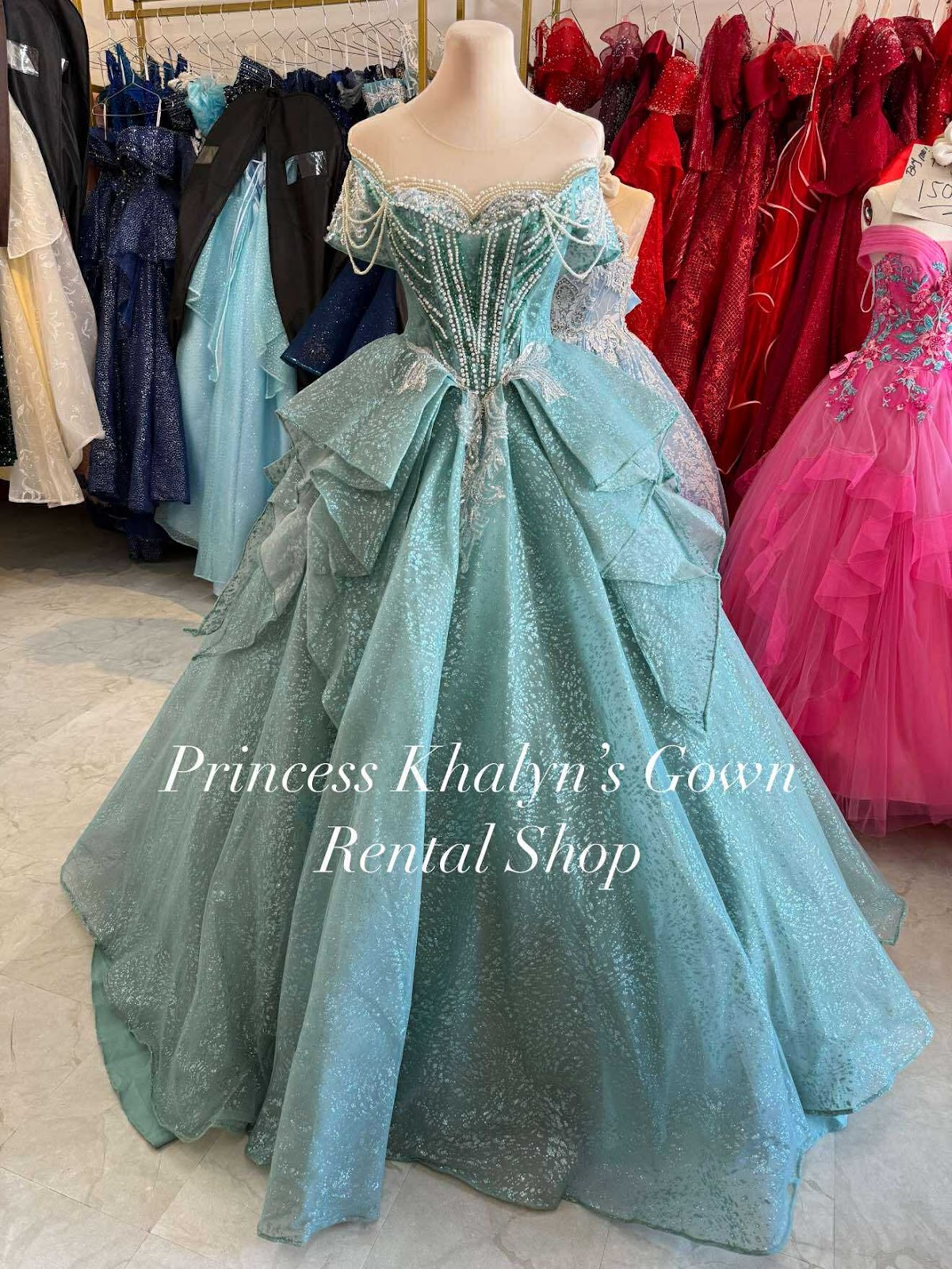 An enchanting aqua ball gown featuring intricate beading and layered tulle, designed for elegant occasions.